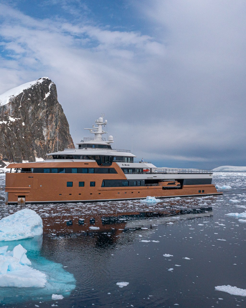 Built for the Ice. La Datcha among sea ice beneath a rocky Antarctic peak.