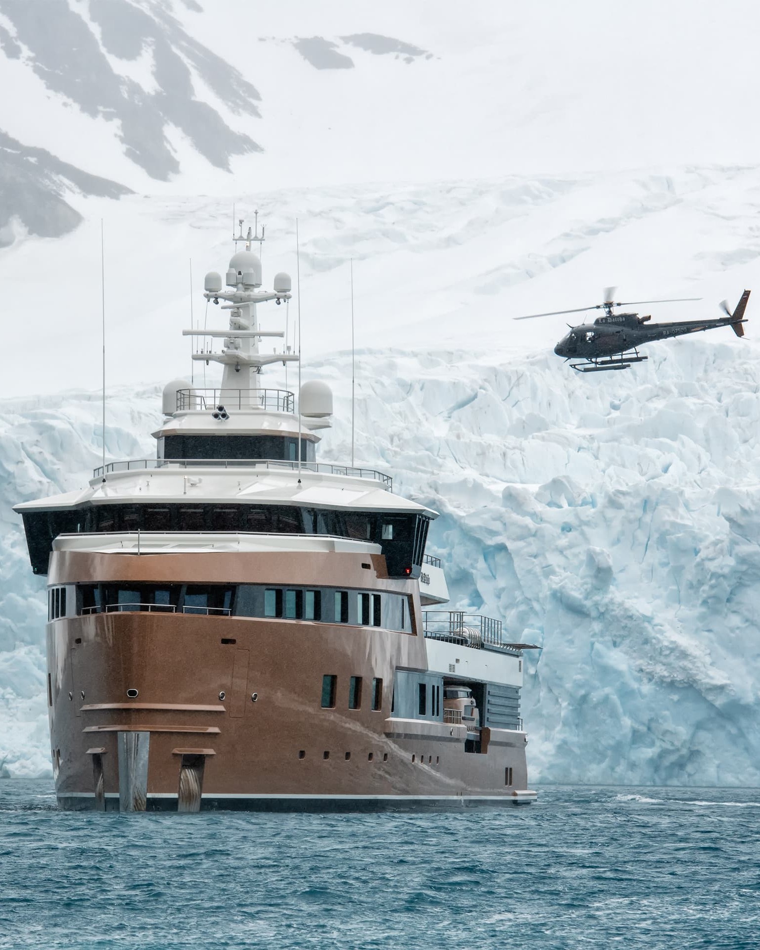 Two Helicopters. A helicopter lifts off beside La Datcha at a glacier face.