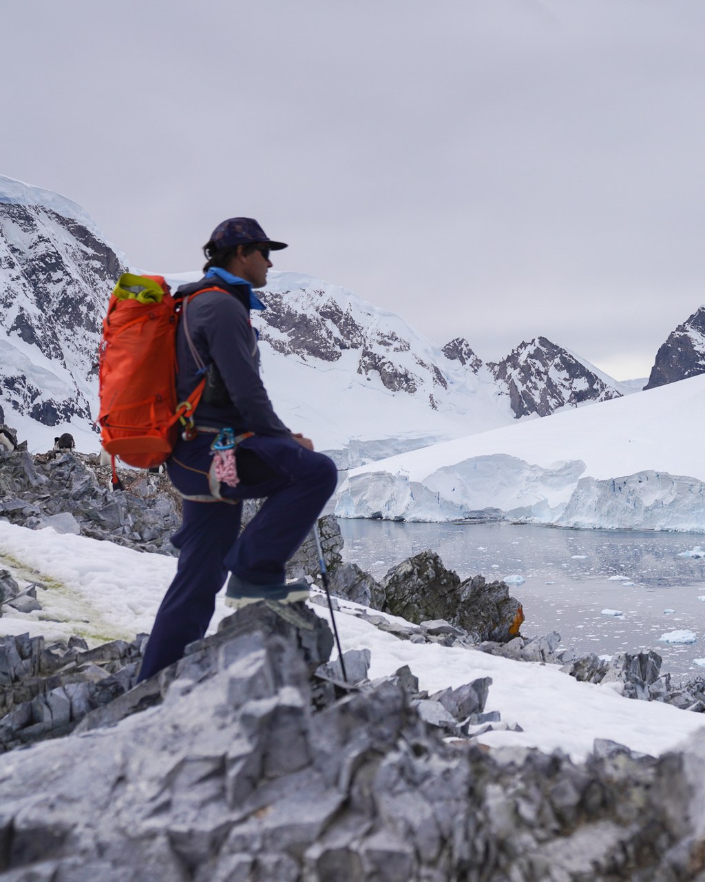 EYOS Expeditions. An expedition guide on an Antarctic ridge above the ice.